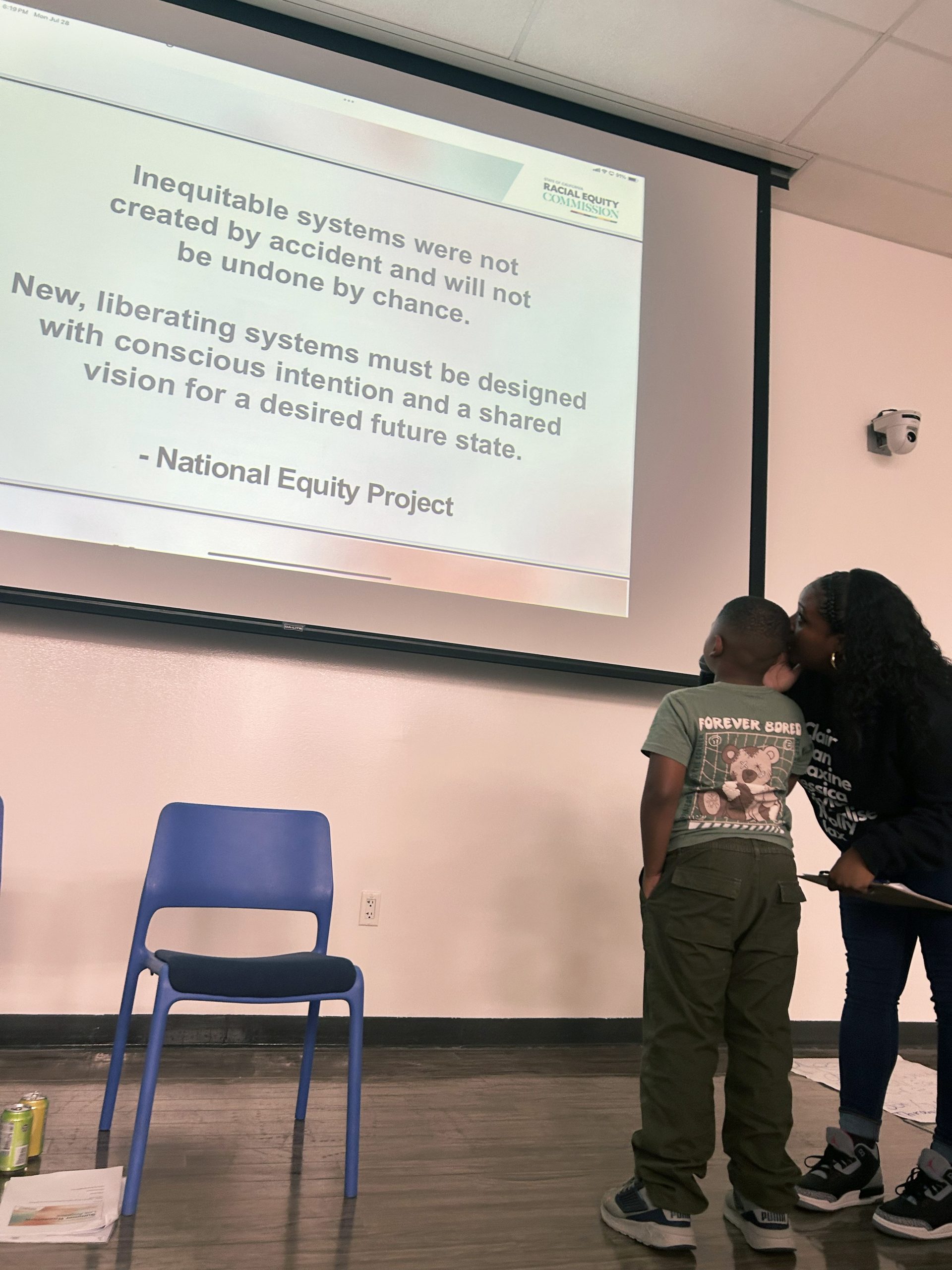 REC's Jourdan Ringgold assists youth participant in reading the community meet and greet closing message in LA